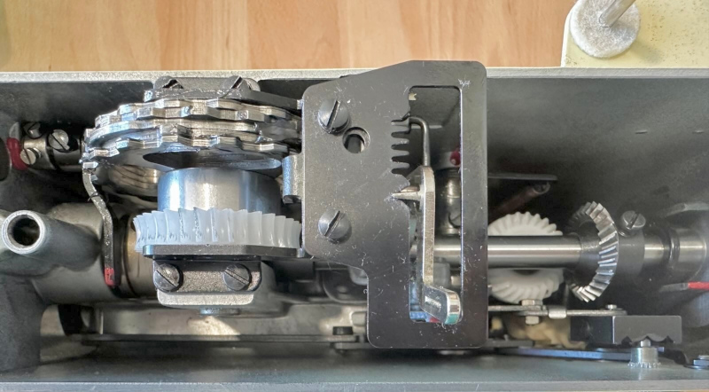 Topview of the Bernina with the cover removed, showing the inside and two plastic gears