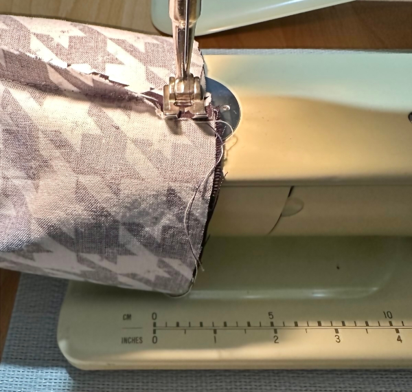a half-finished sleeve, put around the free arm of a Bernina 707 sewing machine, with the presser foot lowered
